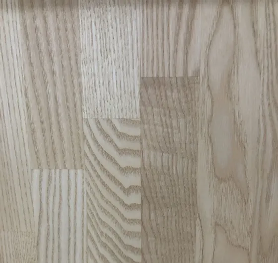 Detail světlé jasanové spárovky s výraznou kresbou letokruhů.