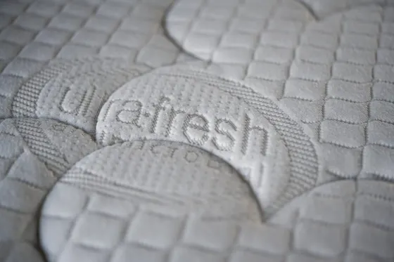 Detail prošívaného potahu matrace s vetkaným nápisem Ultra-Fresh.